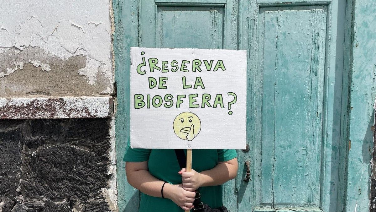 Una mujer sostiene un cartel en Lanzarote el que se puede leer ''¿Reserva de la Biosfera?''