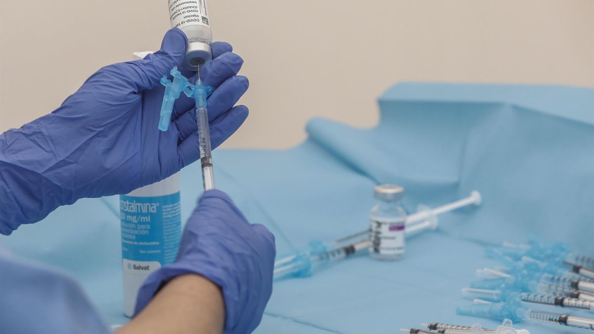 Una profesional sanitaria sostiene una jeringuilla junto a un vial con la vacuna de AstraZeneca, en el Hospital la Fe, en València.