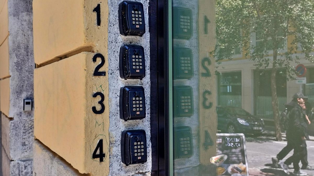 Cuatro cajas para guardar llaves de pisos turísticos en una fachada.