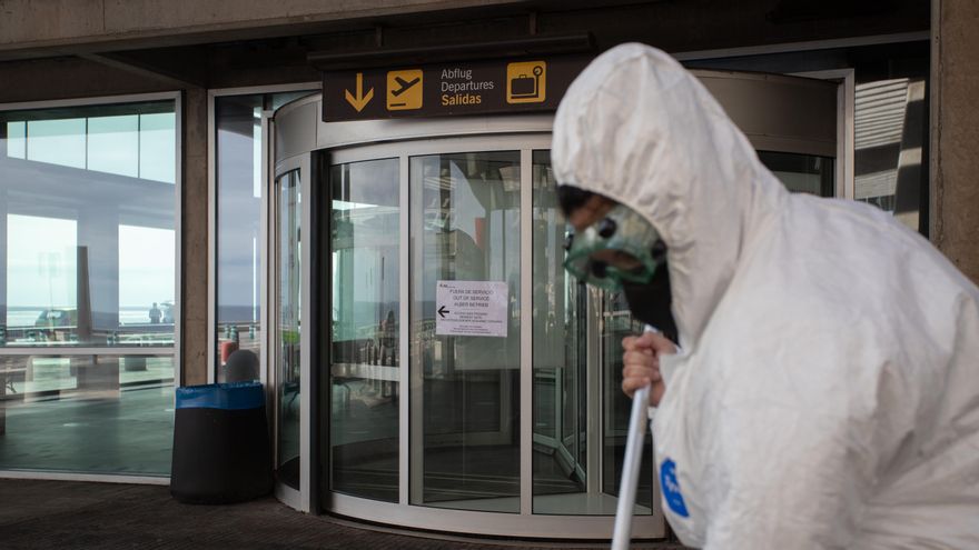 Una trabajadora del aeropuerto de La Palma barre la ceniza del exterior