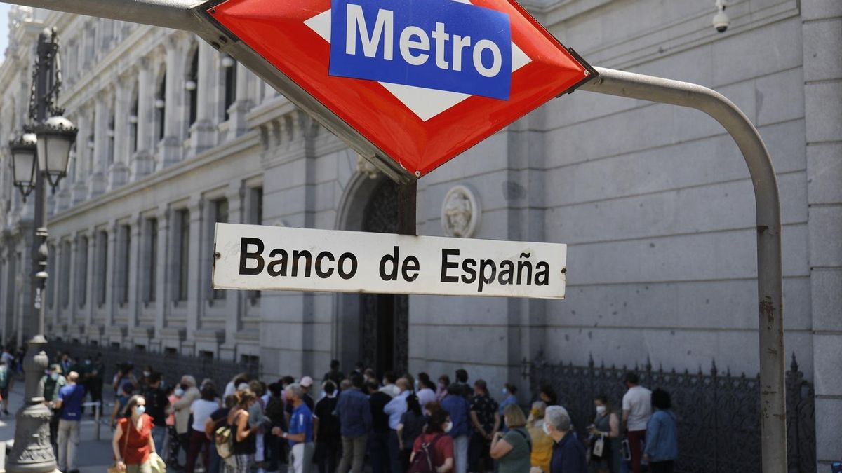 Un grupo de personas hacen cola en la puerta del Banco de España.