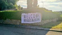 Jóvenes de Vox colocan una pancarta en el chalé de Iglesias y Montero con el lema 'Welcome Refugees & Ocupas'