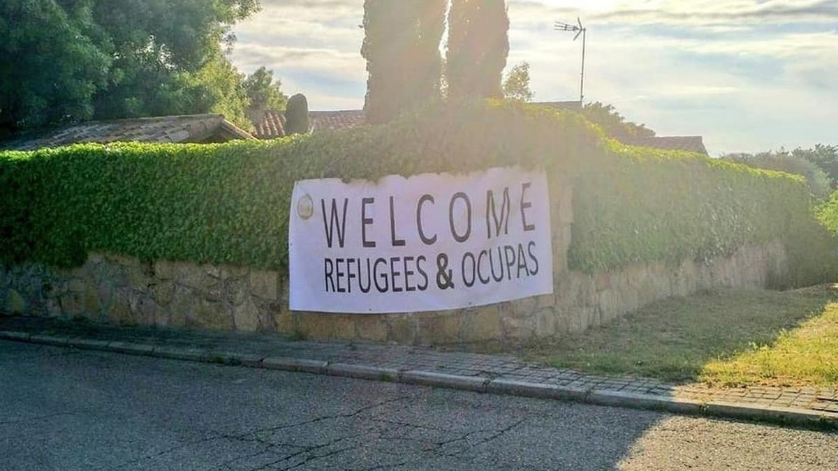 Jóvenes de Vox colocan una pancarta en el chalé de Iglesias y Montero con el lema 'Welcome Refugees & Ocupas'