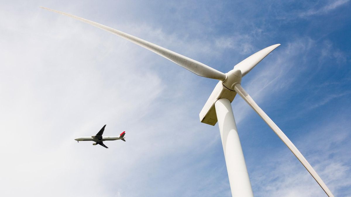 Un avión coexistiendo con la energía eólica