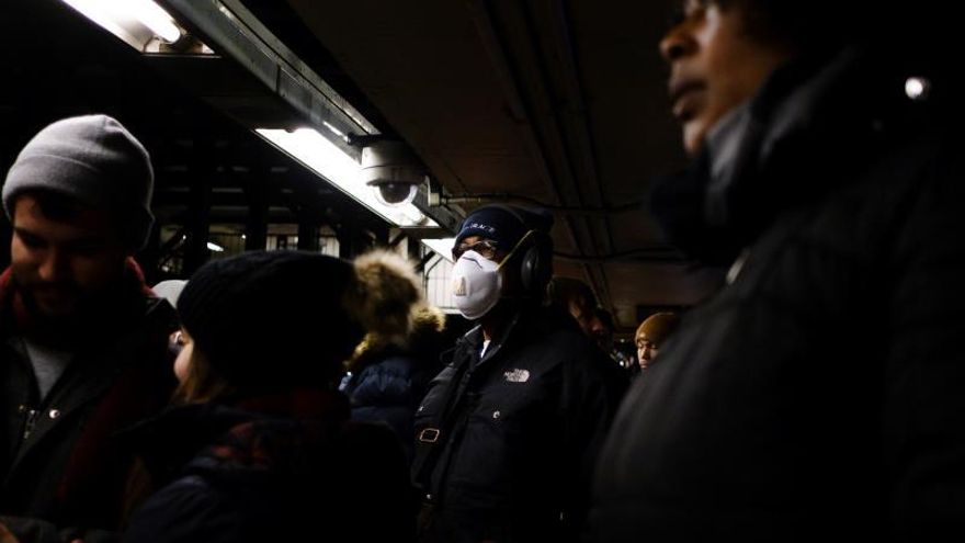 A man wears a mask while waiting for a subway in New York, New York, USA, 28 February 2020. Many people around the world are wearing masks in an effort to protect themselves from the coronavirus, though medical experts are advising that basic paper masks have a limited ability to protect people.