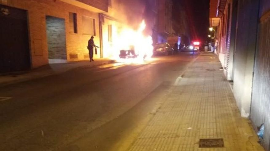 Un policía local de León actuando con urgencia ante el incendio de un vehículo.