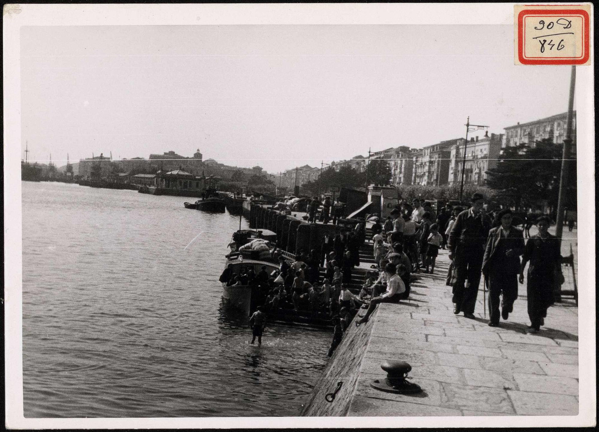 "Descargando víveres y evacuados y niños bañándose". | Biblioteca Nacional de España