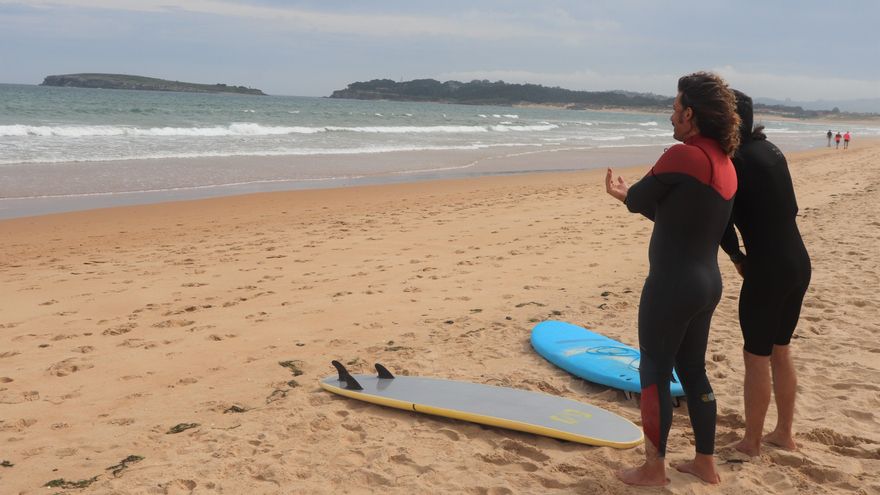 Claudio y Juanma se preparan para entrar al agua mientras el primero da explicaciones al segundo sobre la situación del mar.