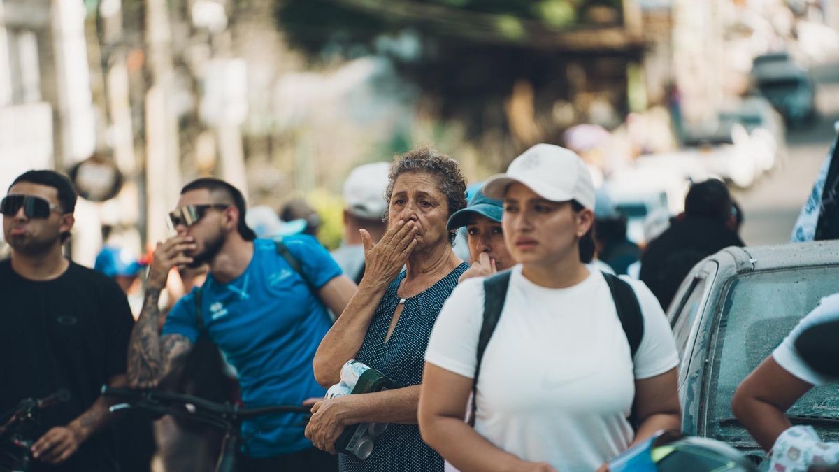 Vecinos guardan silencio a petición de los rescatistas durante las labores de búsqueda de supervivientes del terremoto en Pereira (Colombia)