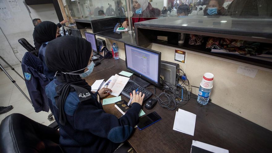 Policías de control palestinos verifican los pasaportes de los pasajeros antes de cruzar el puente Allenby, el único cruce entre la Ribera Occidental y Jordania.