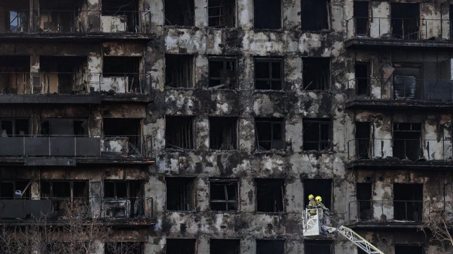 Los bomberos enfrían la fachada del edificio incendiado en el barrio de Campanar de València a primera hora de la mañana de este viernes.