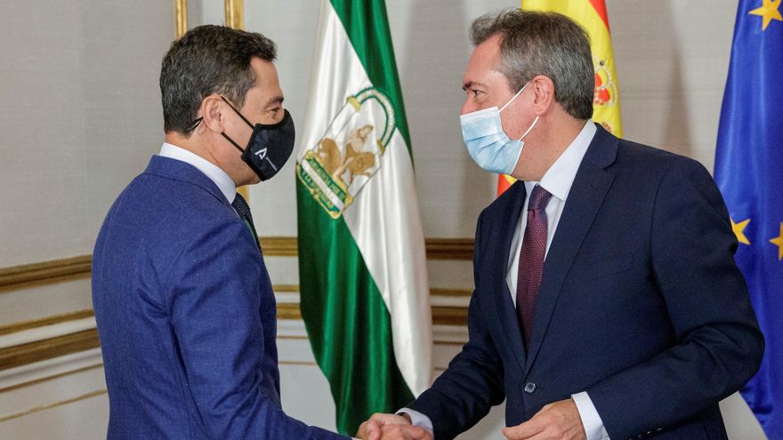El presidente de la Junta de Andalucía, Juanma Moreno, y el líder del PSOE-A, Juan Espadas, se saludan al comienzo de la reunión mantenida este viernes en el Palacio de San Telmo. EFE/ Julio Muñoz