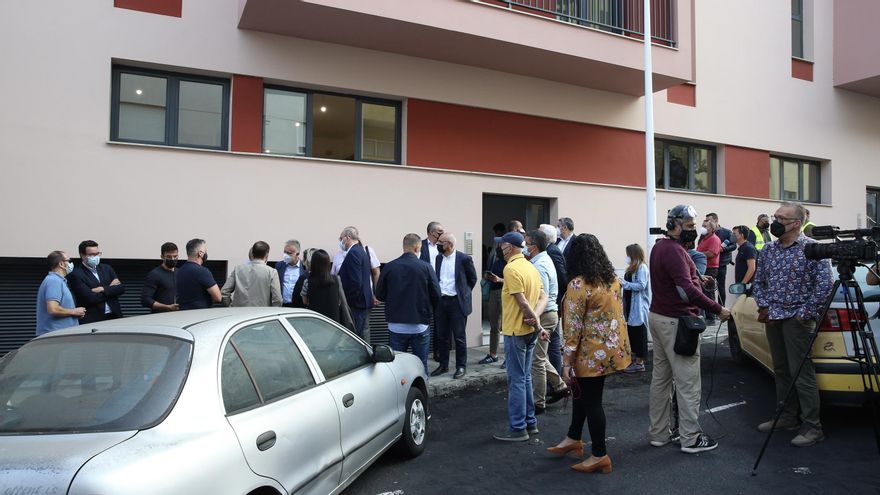 Representantes institucionales, medios de comunicación y vecinos a la entrada de edificio de Tazacorte con viviendas destinadas a los afectados por el volcán.