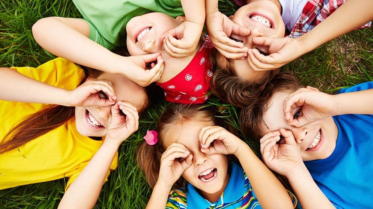 Group Of Cute Children Lying On Grass