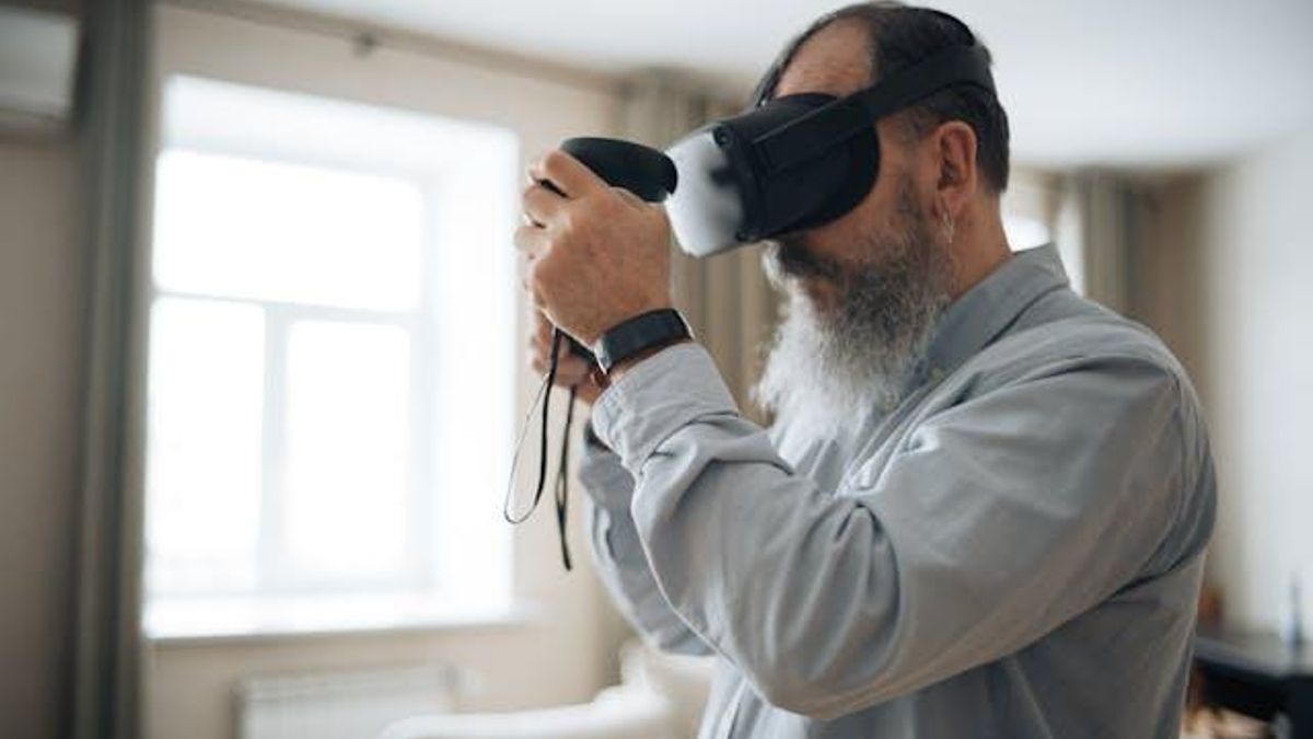 Una persona mayor juega a un videojuego de realidad virtual.