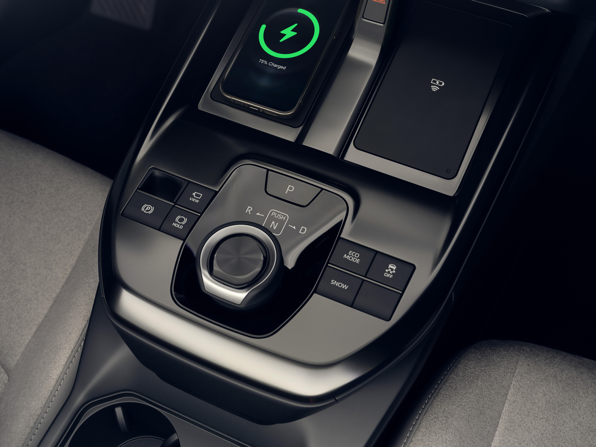 Detalle del doble cargador inalámbrico y del selector de cambio.