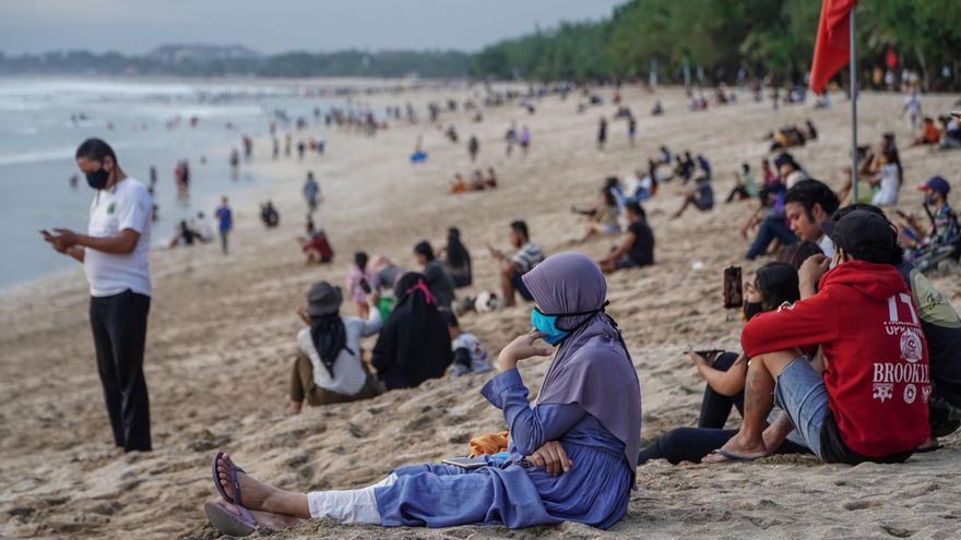 Las personas acuden en masa a la famosa playa de Kuta, en Indonesia, cuando el gobierno local comienza a reabrir playas para los ciudadanos balineses.