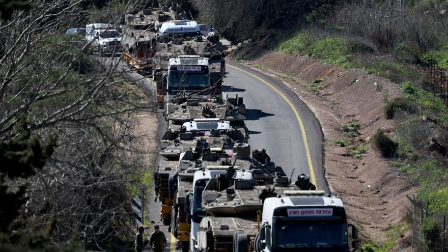 Camiones de transporte pesado cargan tanques israelíes por una carretera cerca de la frontera con el Líbano.