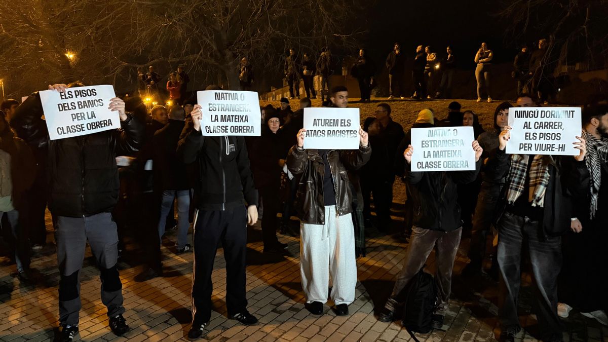 Manifestantes muestran carteles contra el racismo y a favor de facilitar viviendas a los migrantes desalojados