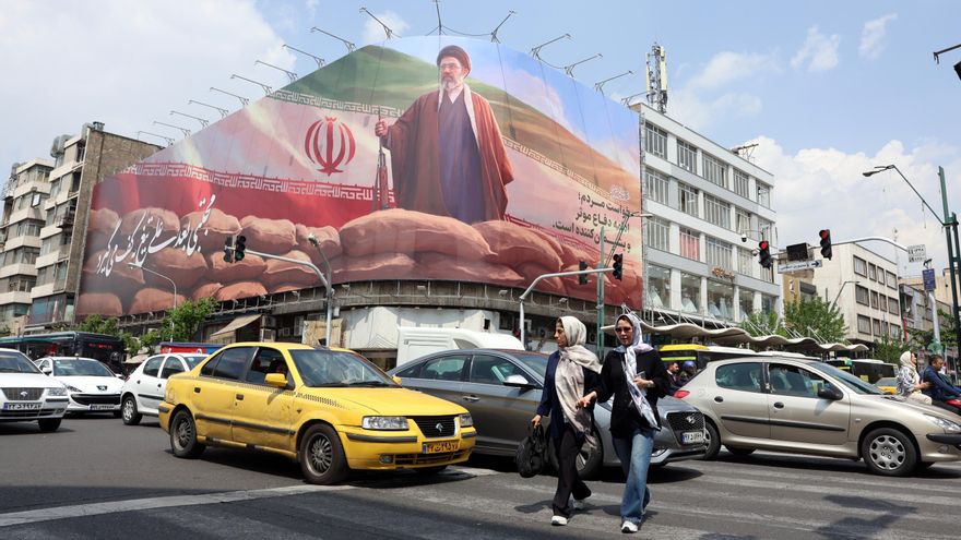 Ciudadanos iraníes caminan junto a una gran valla publicitaria del líder supremo iraní, el ayatolá Mojtaba Jamenei, en una calle de Teherán el 20 de abril de 2026.