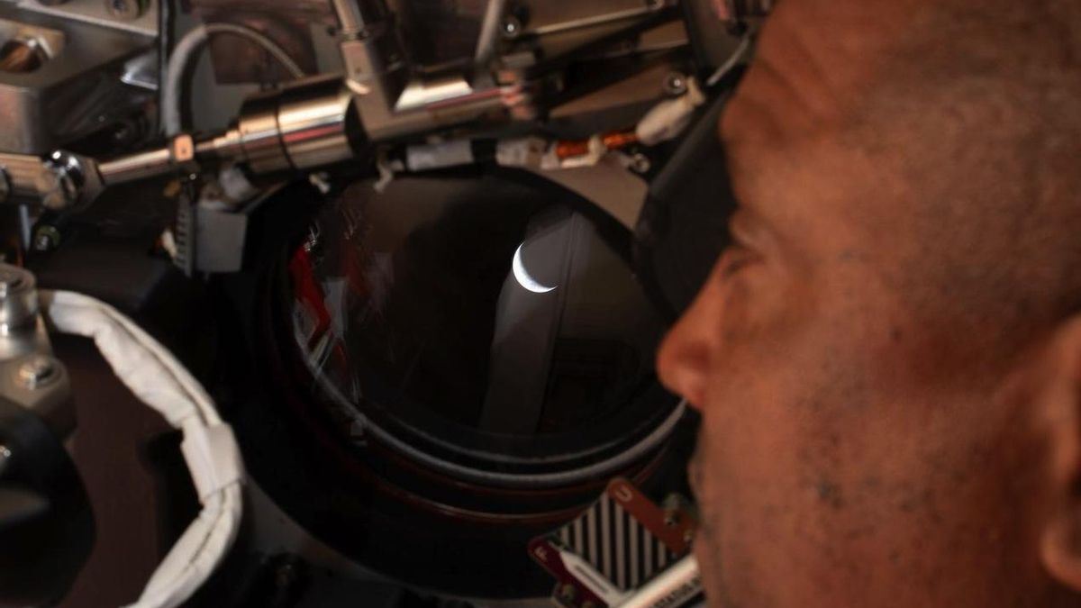 Victor Glover, mira por una de las ventanas de la nave espacial Orion hacia la Tierra antes del sobrevuelo lunar.