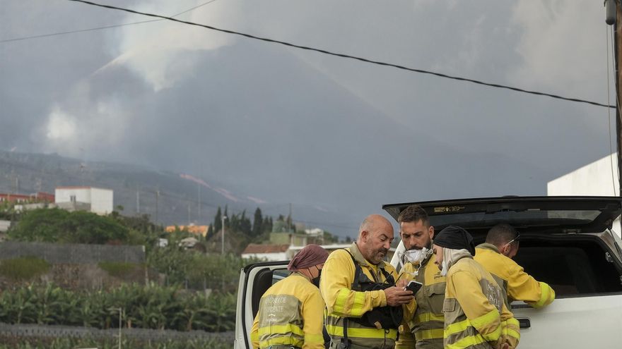 Bomberos, agentes forestales, y personal de Protección Civil y de Cruz Roja en el corte de acceso al barrio de La Laguna para acompañar a los vecinos que tienen permiso para acercase a sus viviendas a recoger algunas pertenecías.