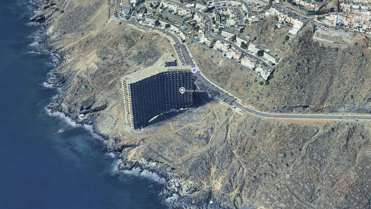El edificio que será demolido y la costa cercana, rocosa y escarpada.