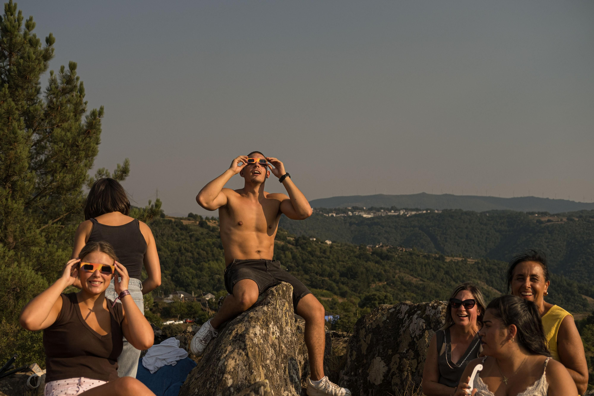 Un grupo de persona observa el eclipse desde un mirador de la Ribeira Sacra, junto al río Sil, en Galicia