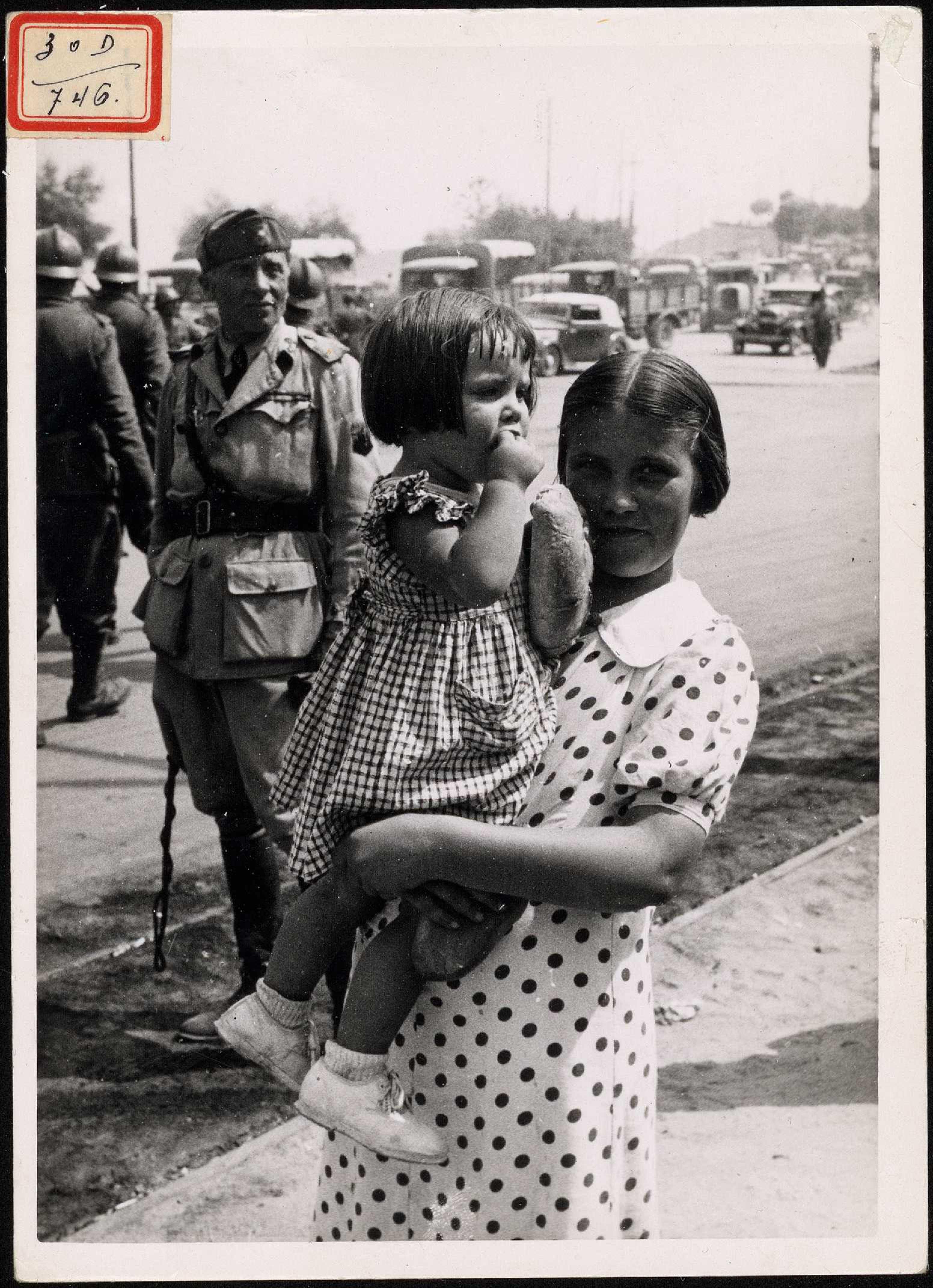 "Una niña saboreando el plan blanco que le han facilitado las tropas nacionales". | Biblioteca Nacional de España