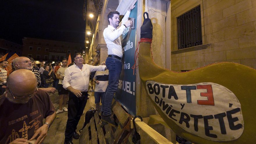 El candidato de Teruel Existe, Diego Loras, durante la pegada de carteles.
