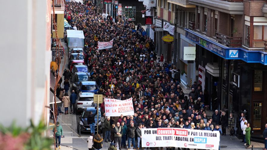 Centenares de trabajadores de la empresa Aspla sostienen pancartas durante una manifestación,