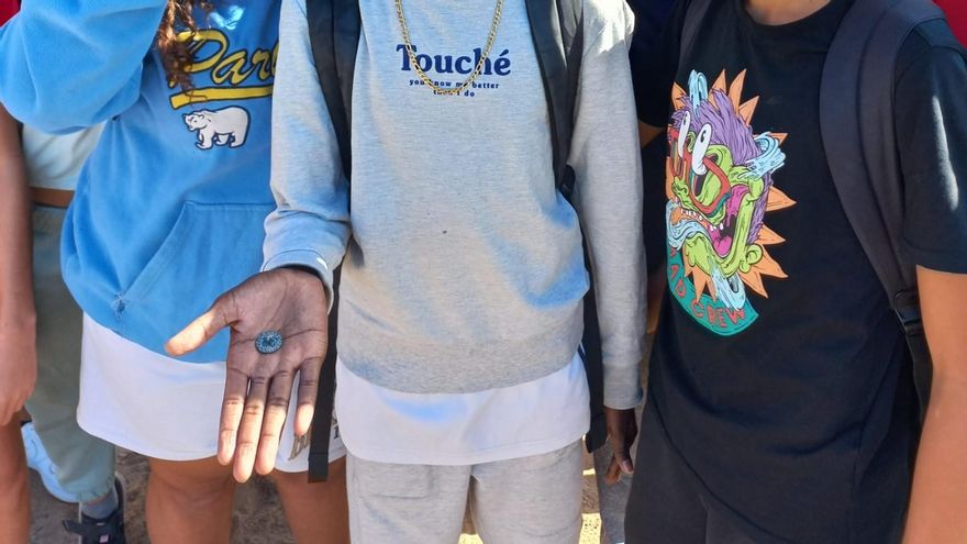 Alumnado que participó en el hallazgo, muestra la moneda.