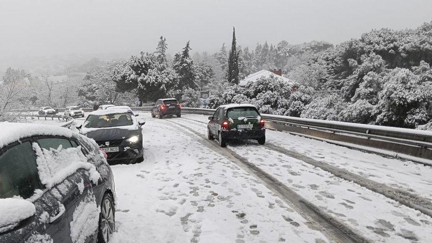 arios coches circulan durante una nevada en Galapagar (Madrid), este miércoles.