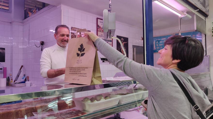 Una clienta recoge la bolsa poética de la carnicería de Germán