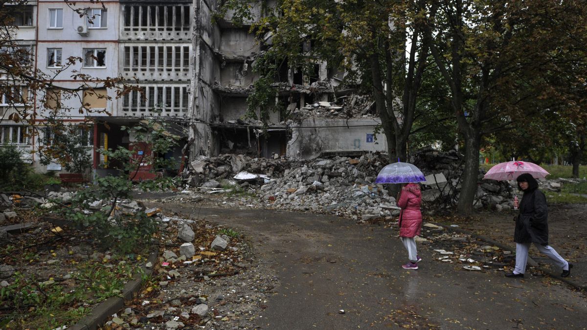 Gente camina cerca de un edificio residencial dañado por los bombardeos del ejército ruso en Saltivka.