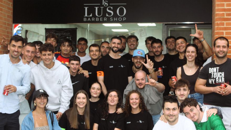 Luis Serrano, en el centro, con un grupo de amigos y amigas, delante de la barbería, el día de la inauguración, en La Fresneda (Siero).