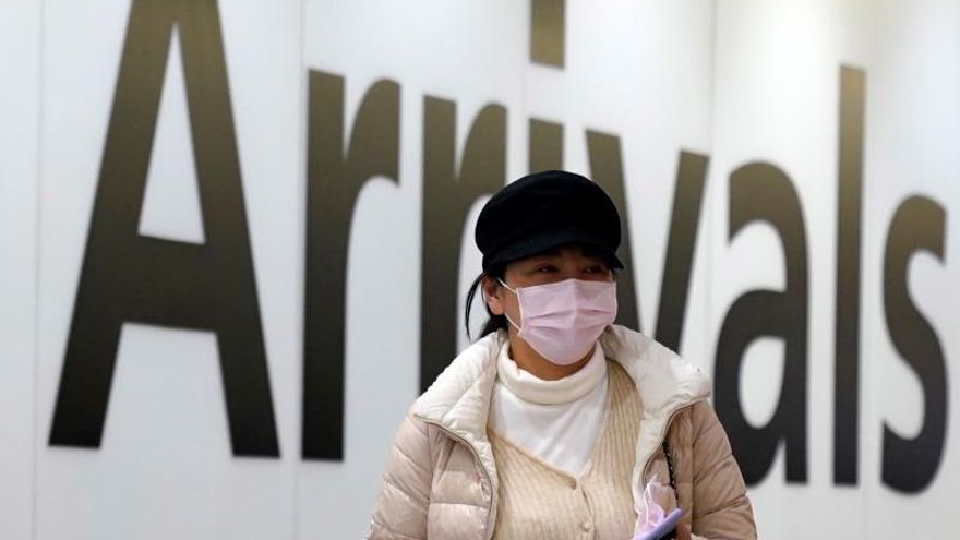 A passenger arrives wearing a mask at Terminal 4, Heathrow Airport, London, Britain, 22 January 2020. Britain will monitor flights arriving from China as a precautionary measure after the spread of a new coronavirus.