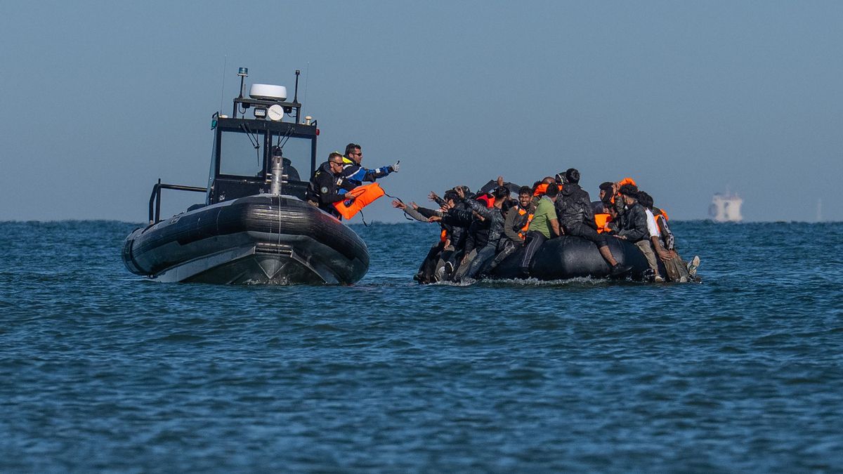 Un barco de la policía francesa entrega chalecos salvavidas a una patera que intenta cruzar el Canal de la Mancha el 25 de agosto de 2025 desde Gravelines (Francia).