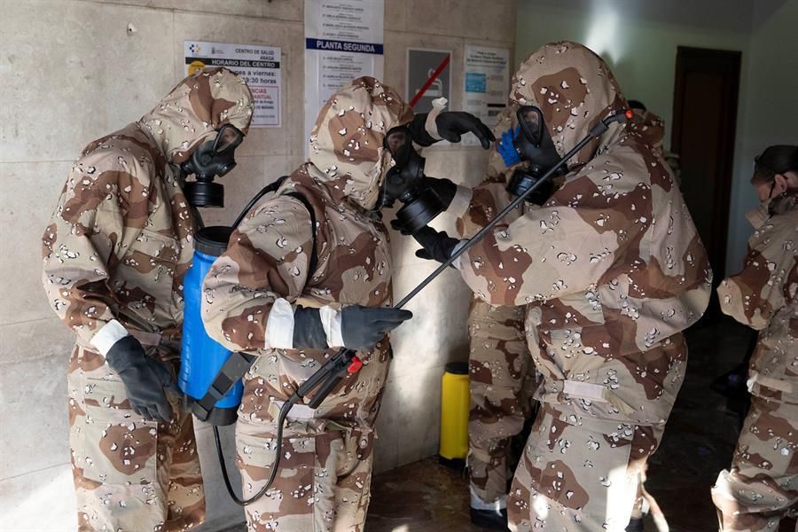 Efectivos del Ejército de Tierra, con trajes de protección, realizan labores de desinfección en el centro de salud de la zona centro de Santa Cruz