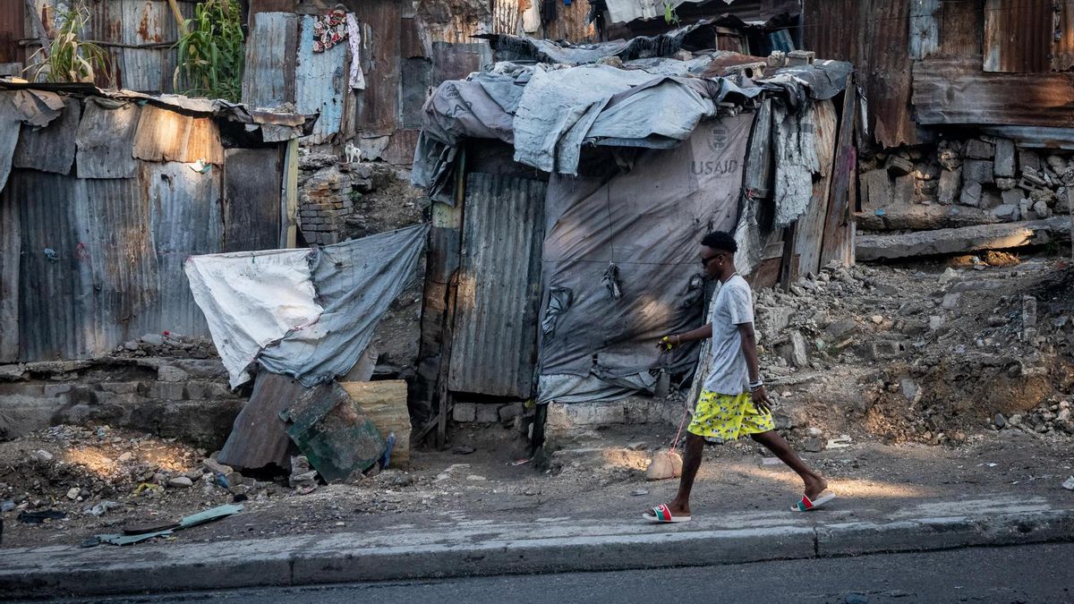 Un hombre camina por una calle del centro de Puerto Príncipe, capital de Haití, repleta de chabolas.