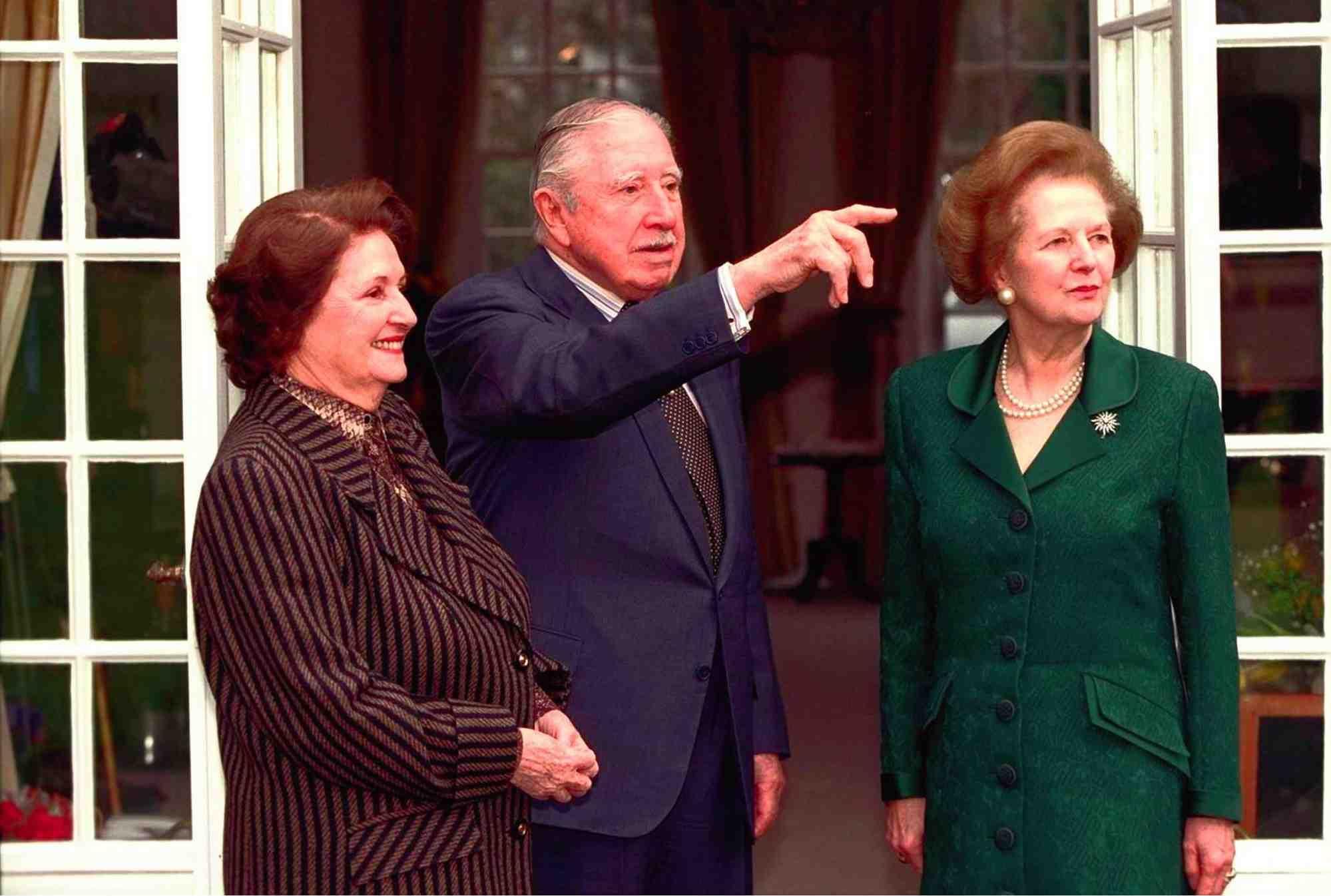 Looking out at the gardens during their meeting Britain's Baroness Margaret Thatcher, right, the former British Prime Minister, with former Chilean president Gen. Augusto Pinochet, and his wife Licia Hiriat, left, Friday March 26 1999 at Gen. Pinochet's rented residence at Wentworth, 25 miles west of London. Britain's highest court ruled on Wednesday, that Pinochet has no absolute immunity from arrest as a former head of state. Baroness Thatcher has campaigned for the former dictator's release since his arrest in London on a Spanish extradition warrant seeking to try him on charges of alleged human rights violations. (AP Photo/Ian Jones, pool)
