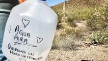 Imagen de una persona voluntaria dejando agua en el desierto.