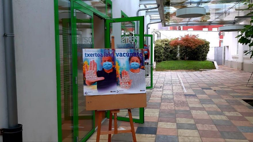 El lema "Este año más que nunca, ¡aléjate de la gripe!", en la entrada de la sala habilitada para vacunar a las personas en el Centro Municipal de Basurto