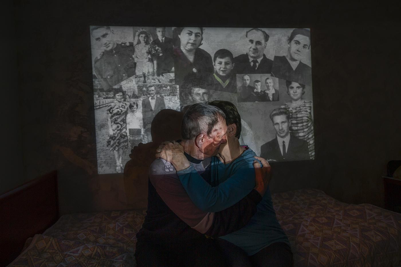 Lyudmila y Nikolai con imágenes de ellos antiguas de fondo.