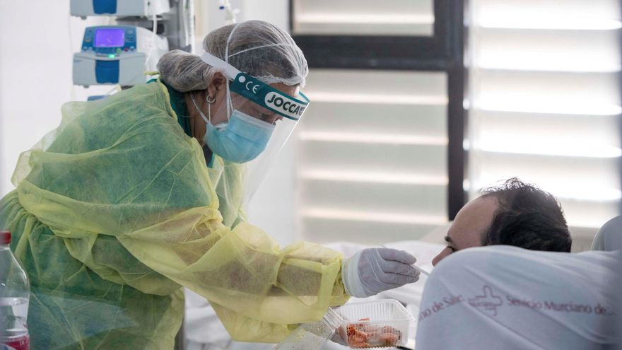 Una sanitaria del centro sanitario da de comer a un paciente ingresado por COVID-19 en la UCI. EFE/Marcial Guillén