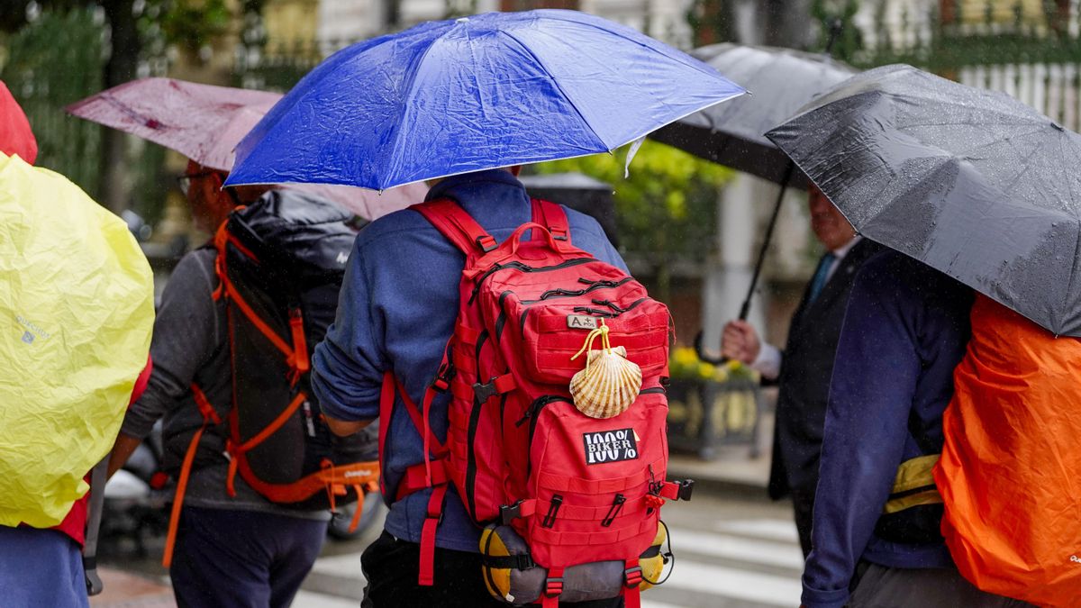 Paseantes y turistas se protegen de la lluvia, en una foto de archivo