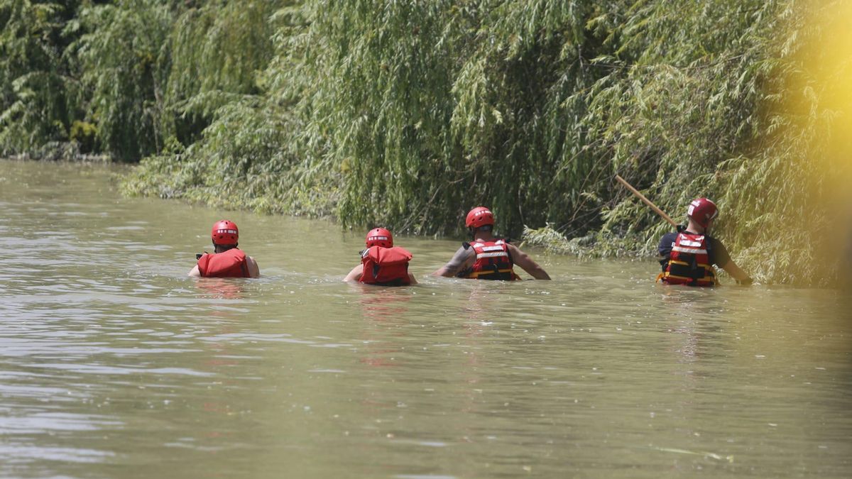 Los bomberos vadeando las zonas menos profundas del Guadalquivir, en una imagen de archivo.