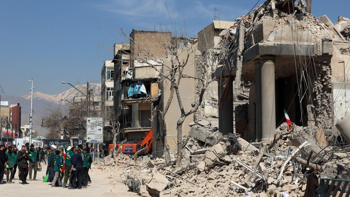 Un grupo de iraníes se reúnen junto a una comisaría de policía dañada en el centro de Teherán el 4 de marzo.