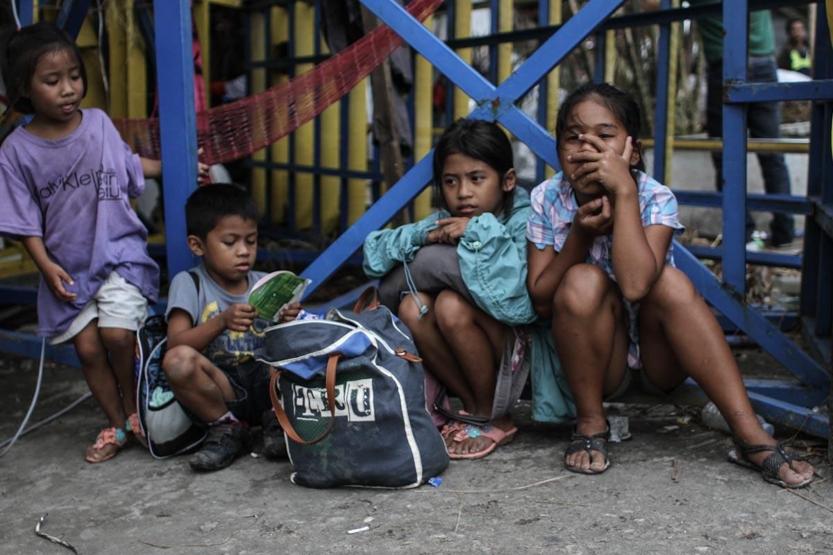Un grupo de niños filipinos, víctimas evacuadas del tifón Yolanda, esperan en las proximidades del aeropuerto de Tacloban el 13 de noviembre de 2013./ Fotografía: Acción contra el Hambre/Daniel Burgui