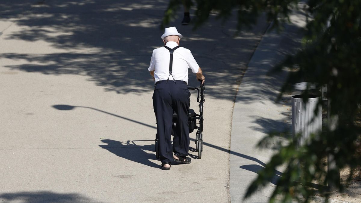 Un anciano pasea por un parque 